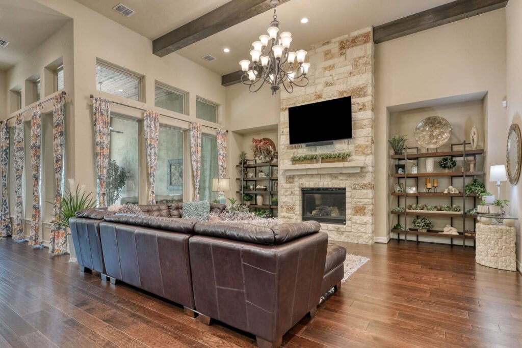 Modern living room with chandelier and leather sofa.