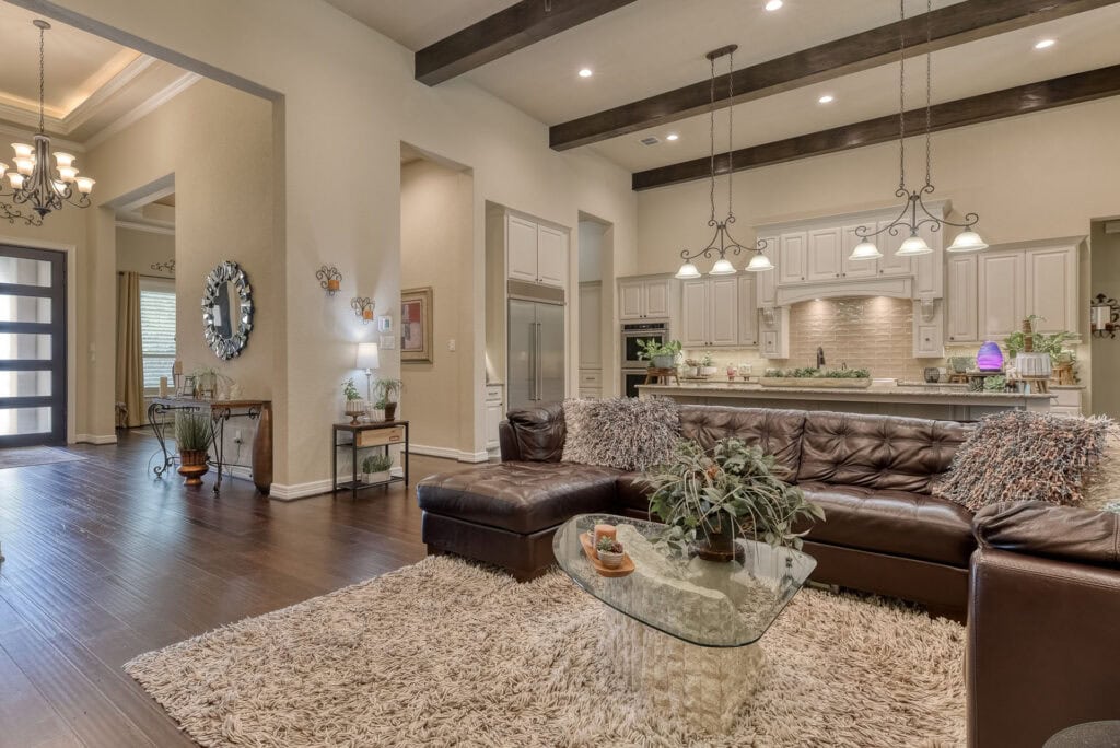 Elegant living room with leather sofa and modern kitchen.