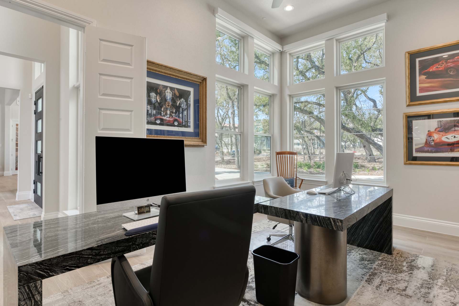 Modern home office with large windows and computers.