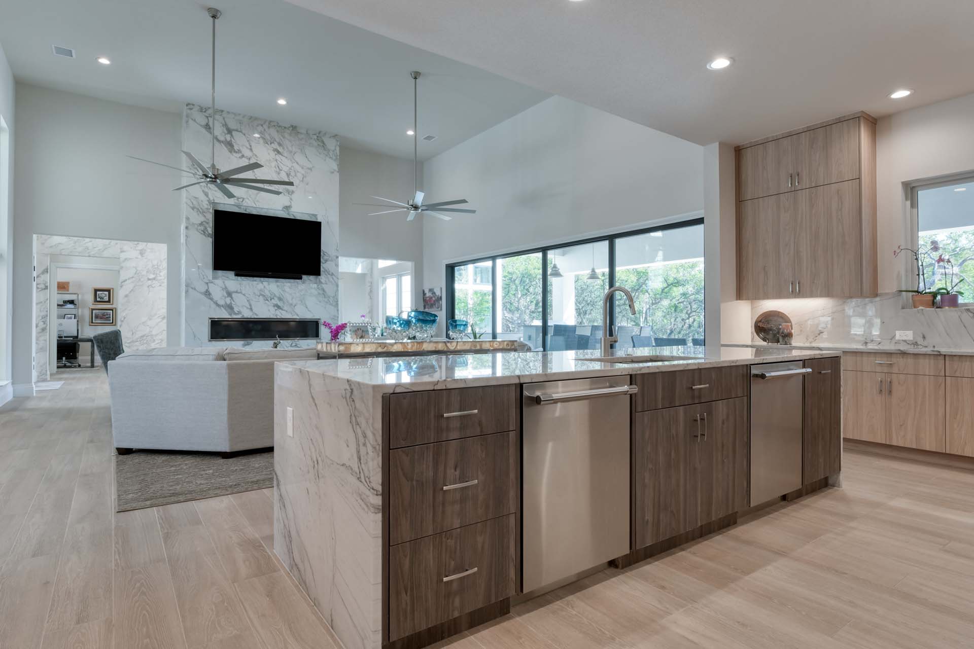Modern kitchen with marble island and stainless appliances.