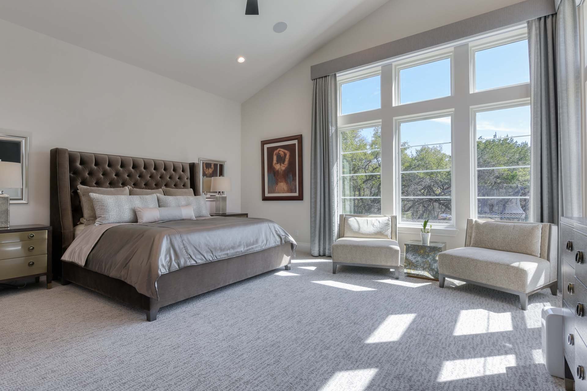 Modern bedroom with large windows and elegant decor.
