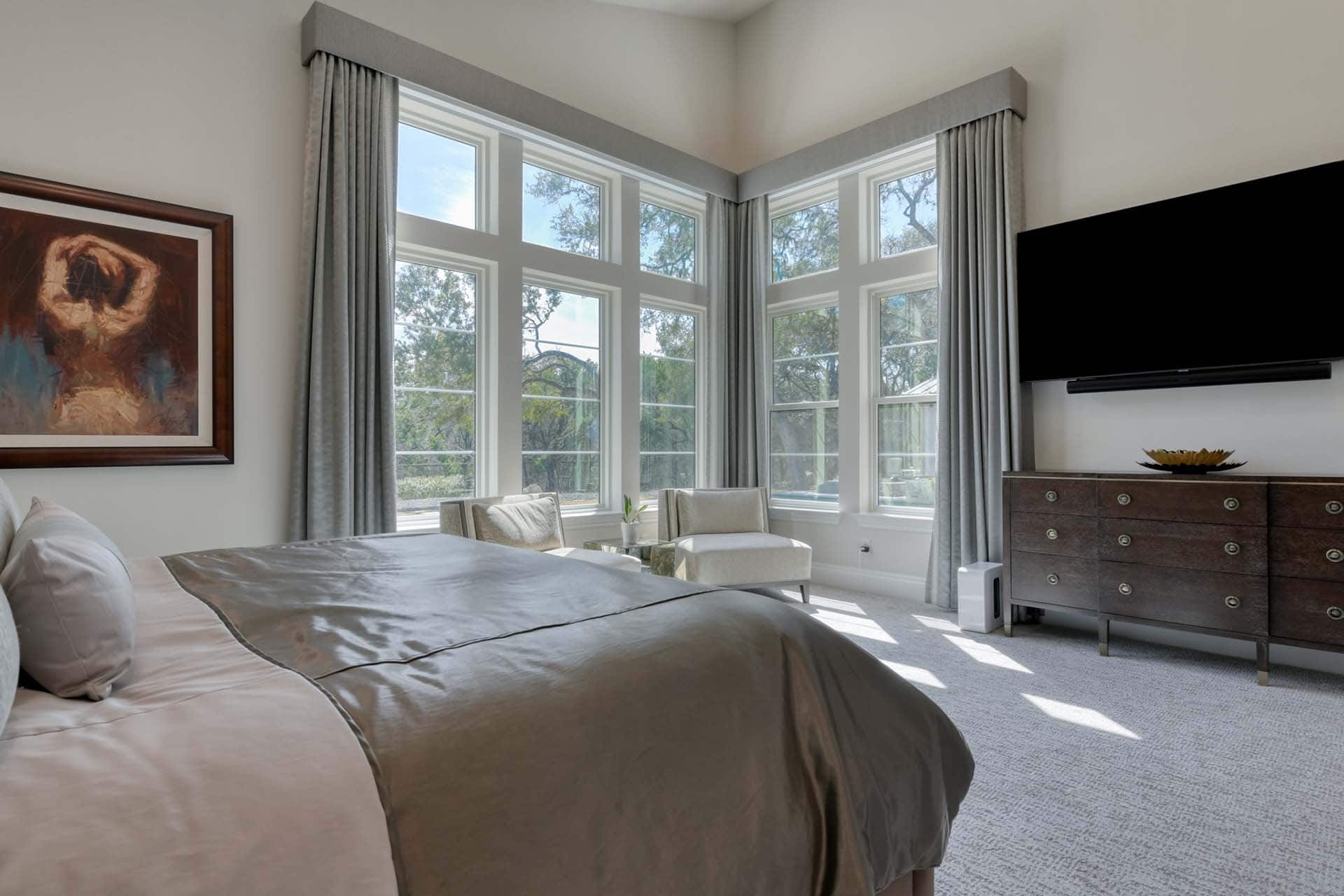 Bright bedroom with large windows and modern decor.