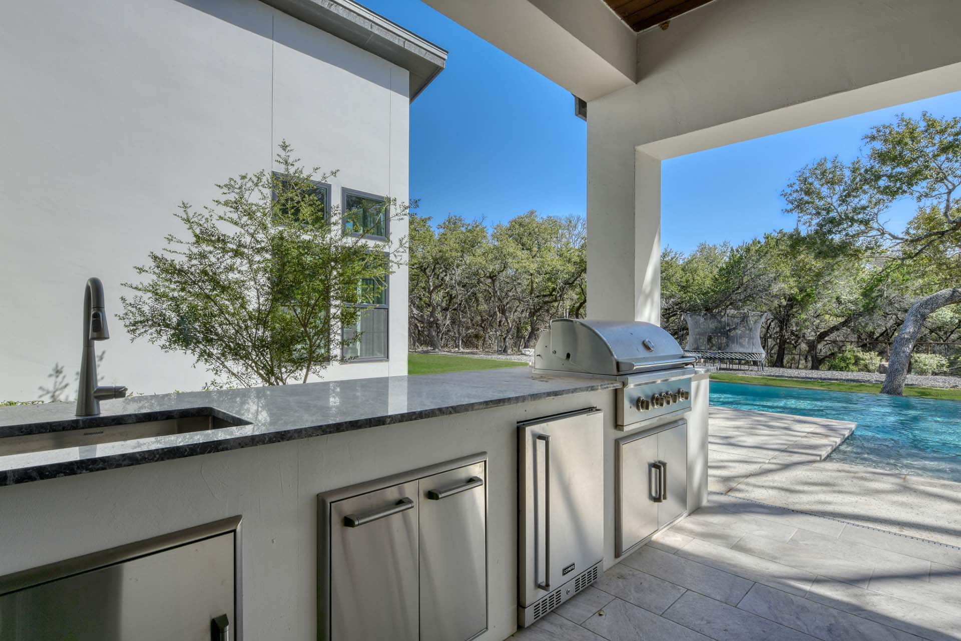 Outdoor kitchen with grill by pool