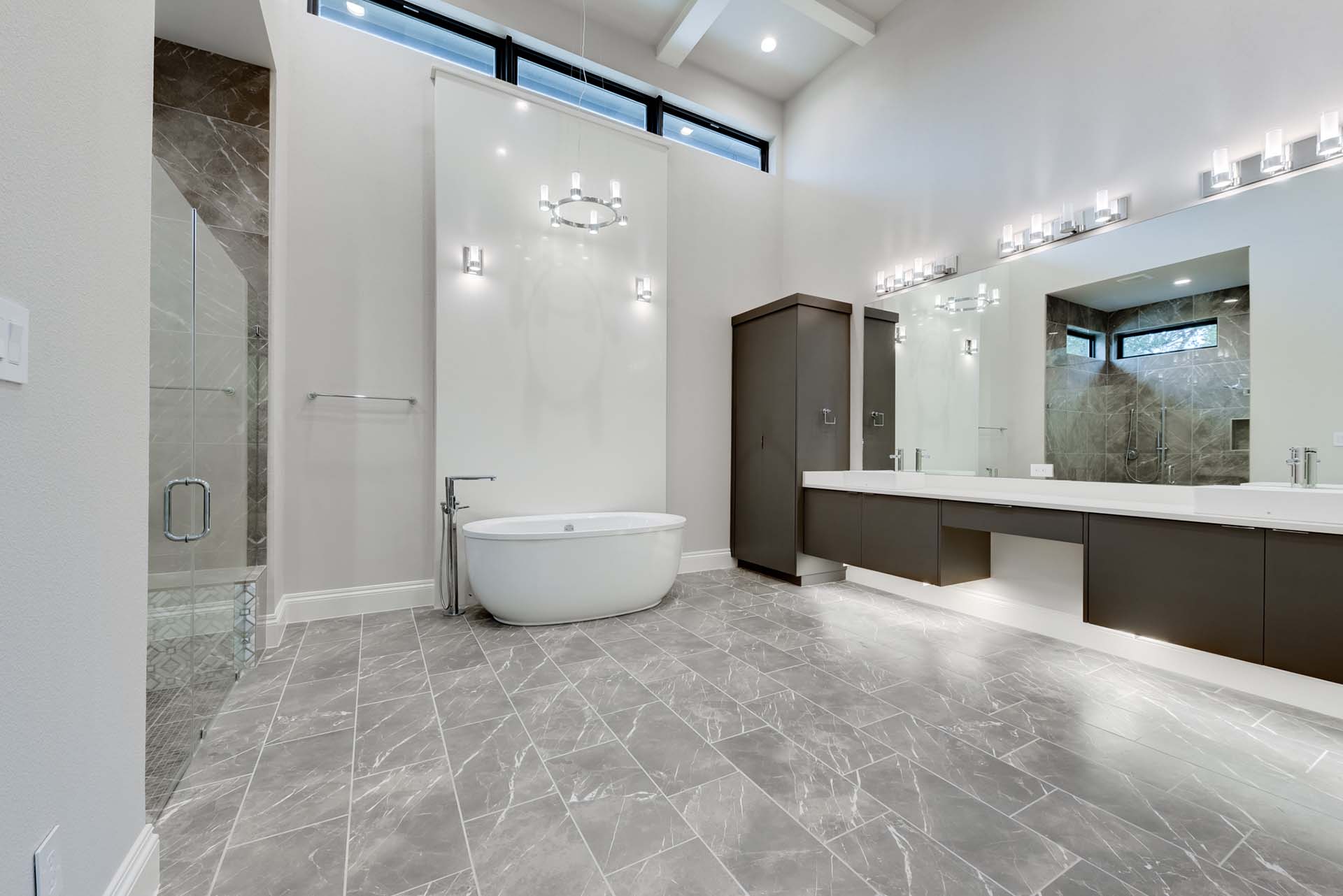 Spacious modern bathroom with bathtub and large mirrors.