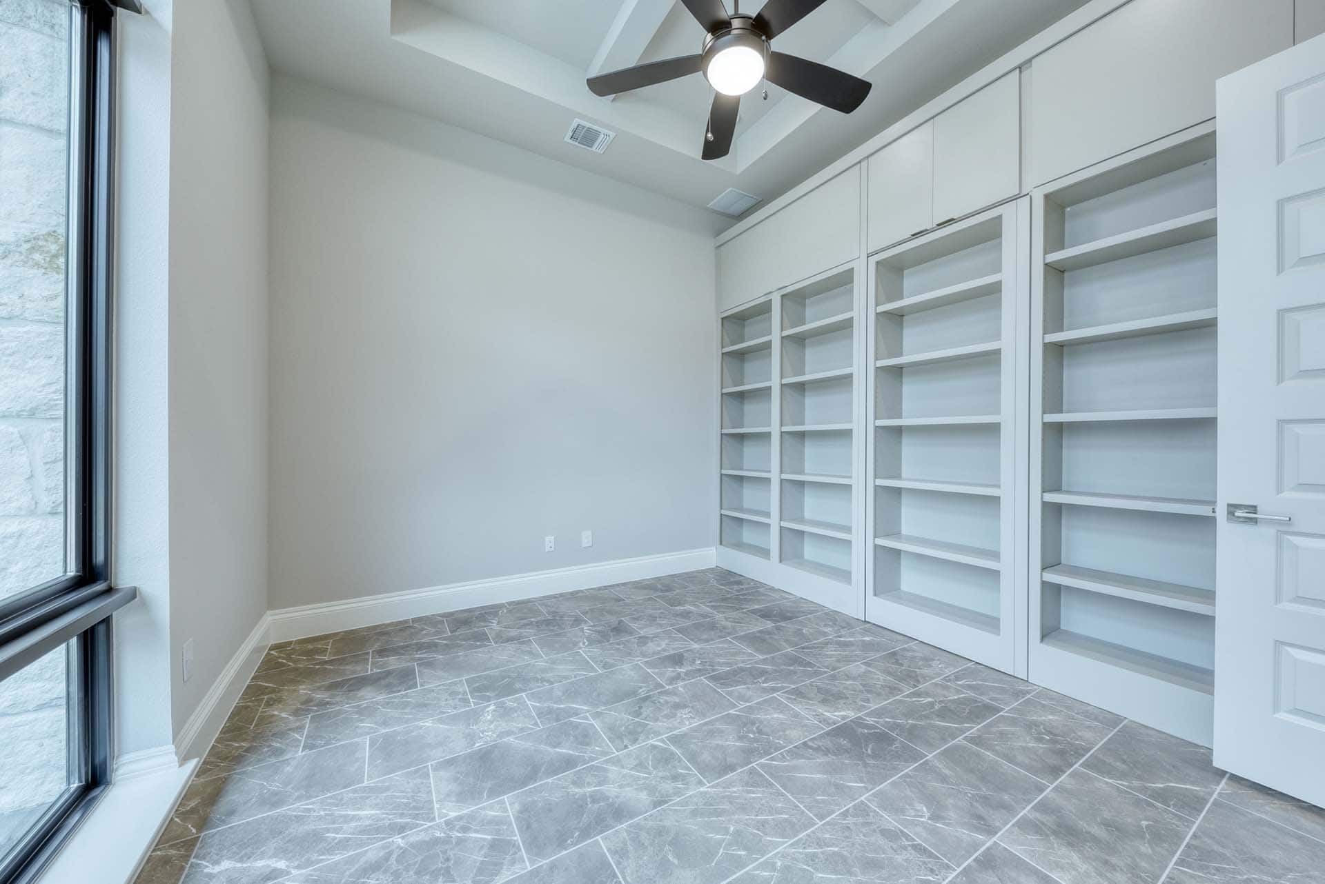 Empty room with shelves and ceiling fan