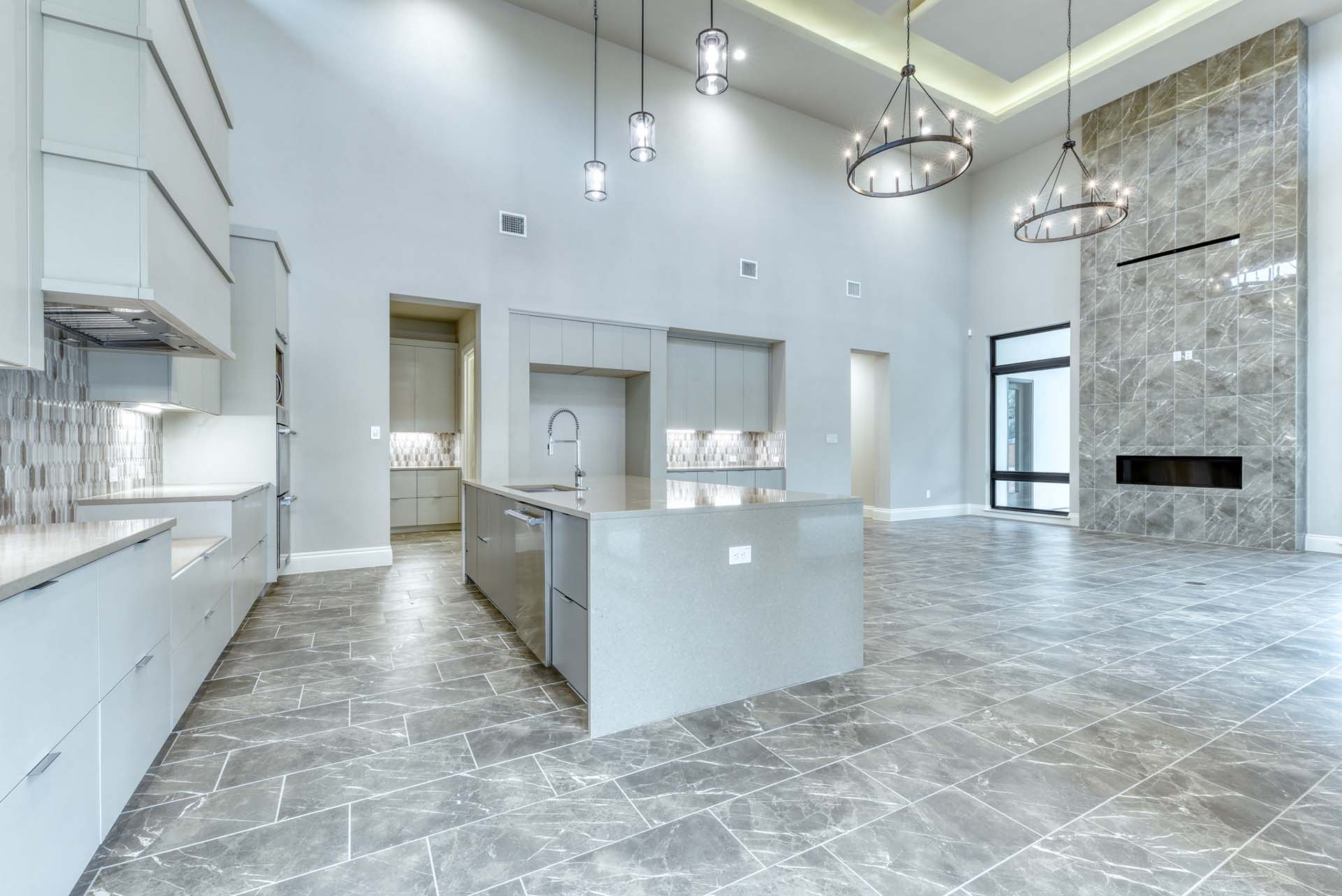 Spacious modern kitchen with marble flooring and island.
