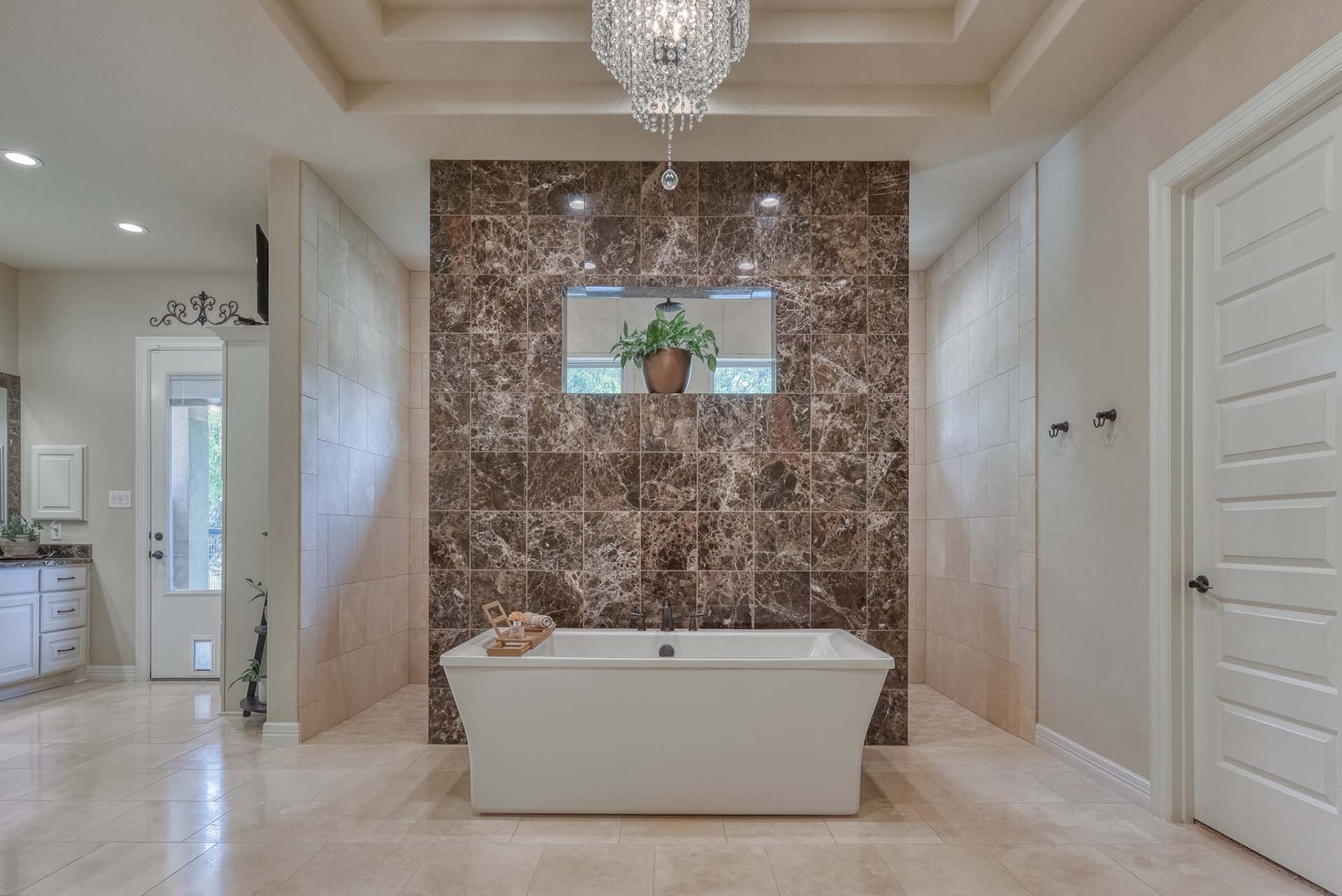Luxurious bathroom with marble tiles and tub.