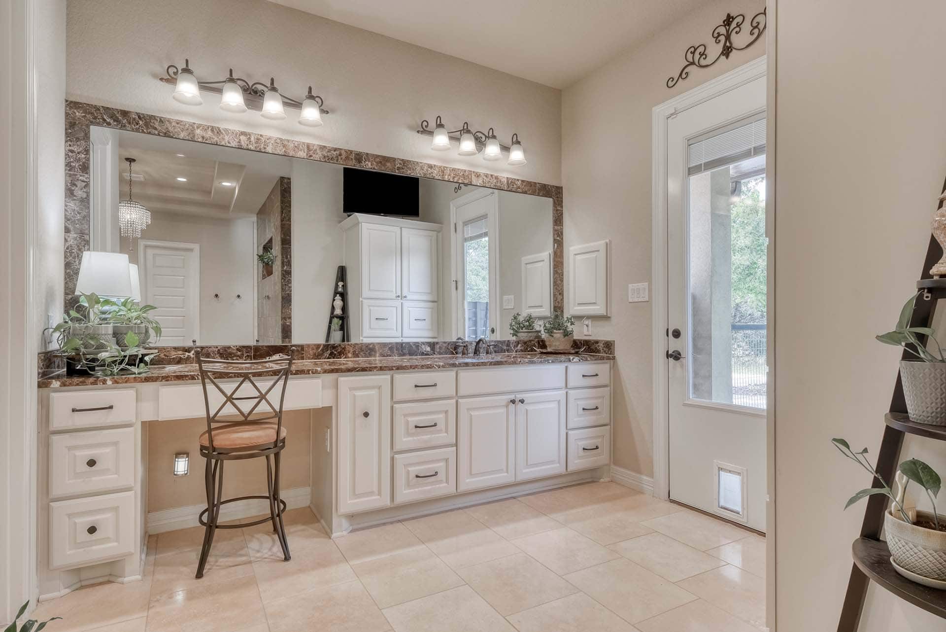 Modern bathroom with large mirror and white cabinets.
