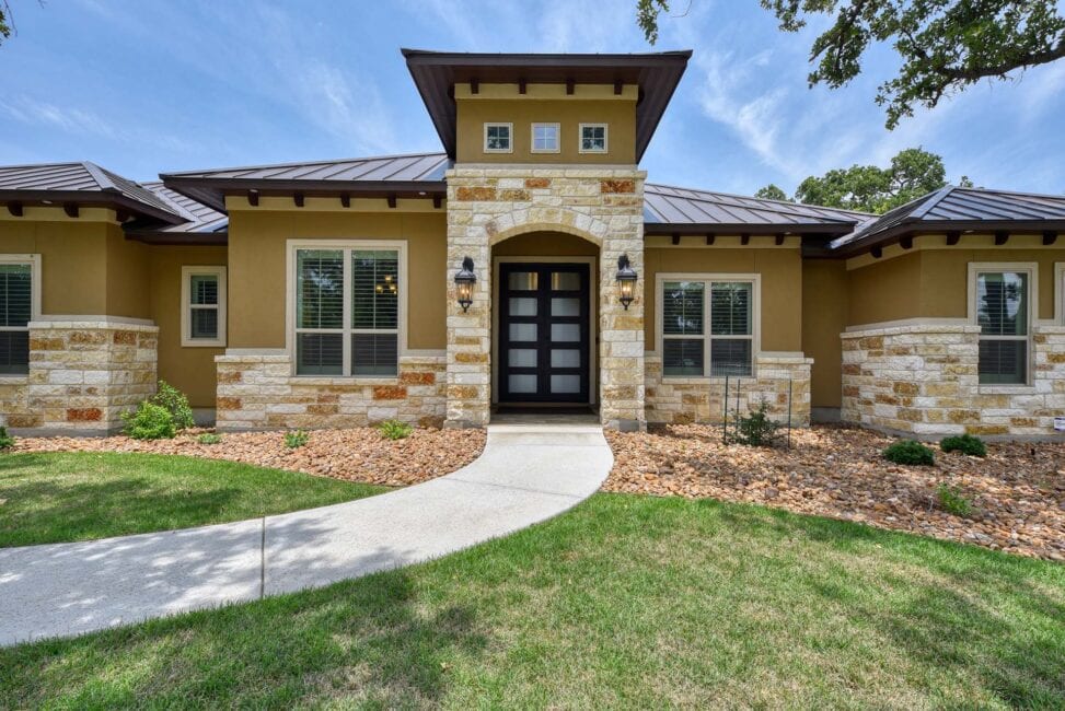 Modern suburban house with stone facade and pathway.