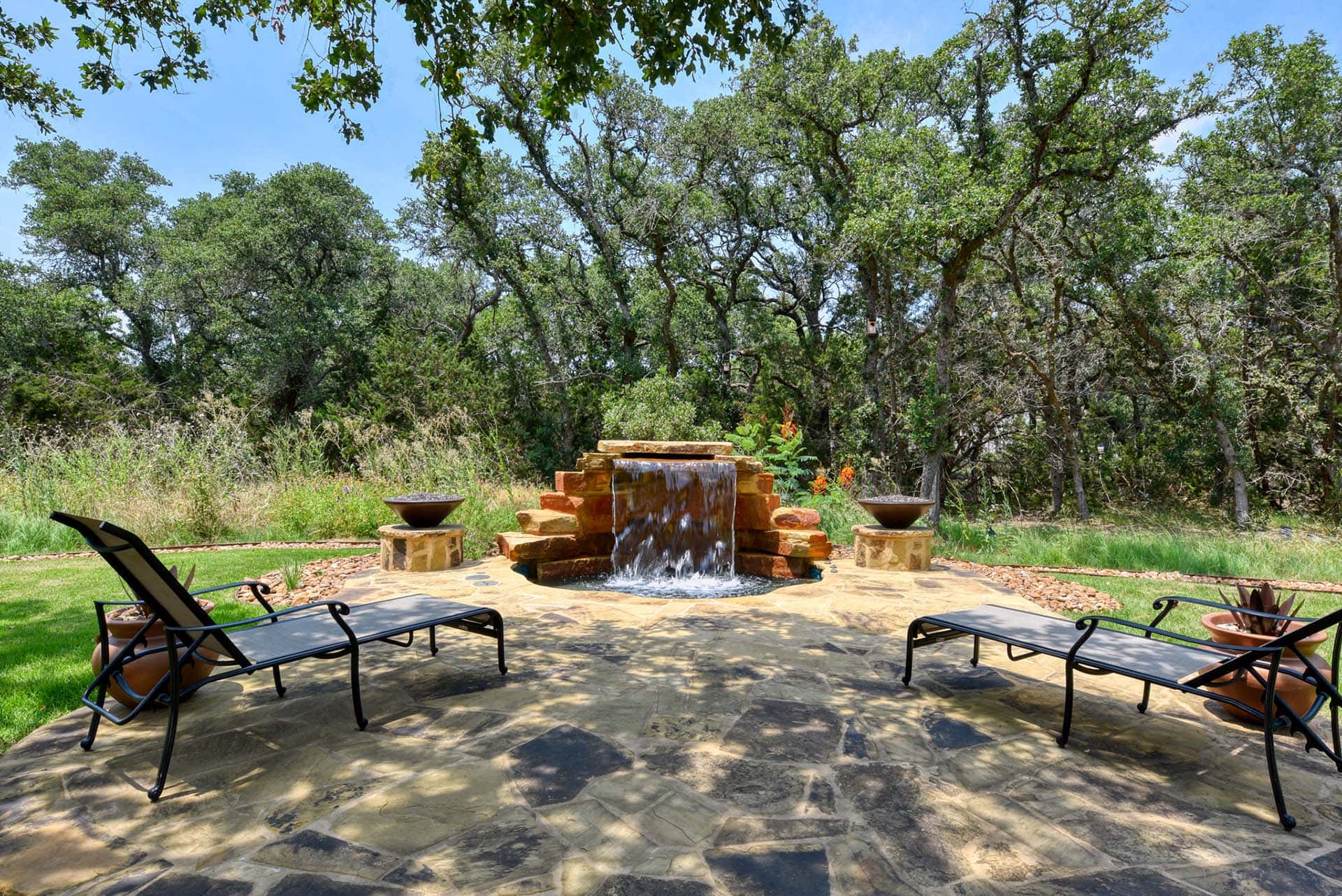 Serene backyard with waterfall and lounge chairs