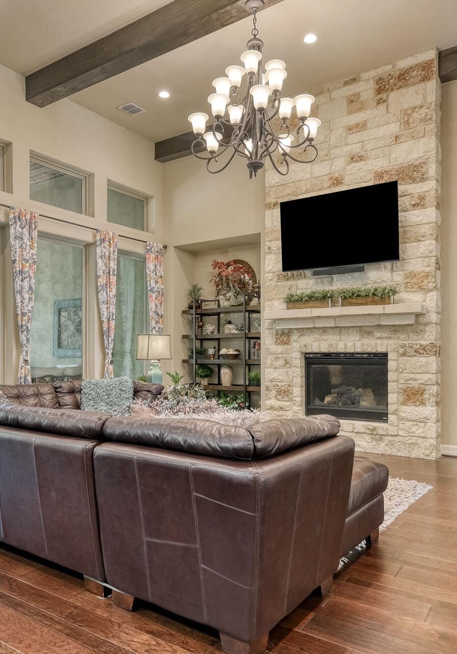 Modern living room with chandelier and leather sofa.